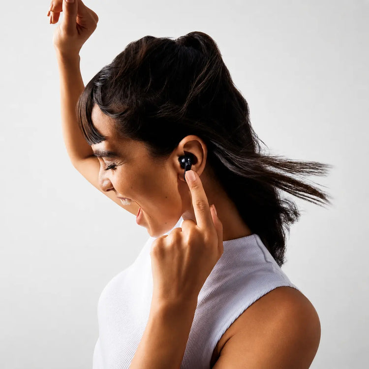 Person touching a black Prelium CMT earbud while wearing it
